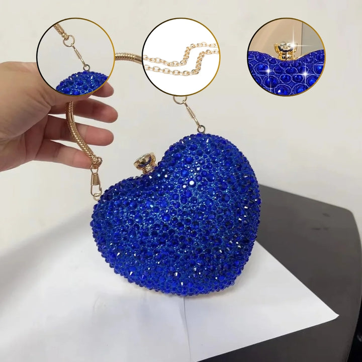 Detalhes da Bolsa clutch festa azul em formato de coração, cravejada com cristais azuis vibrantes, alça metálica dourada estruturada e fecho superior com detalhe em pedra – loja Bolsa Clutch