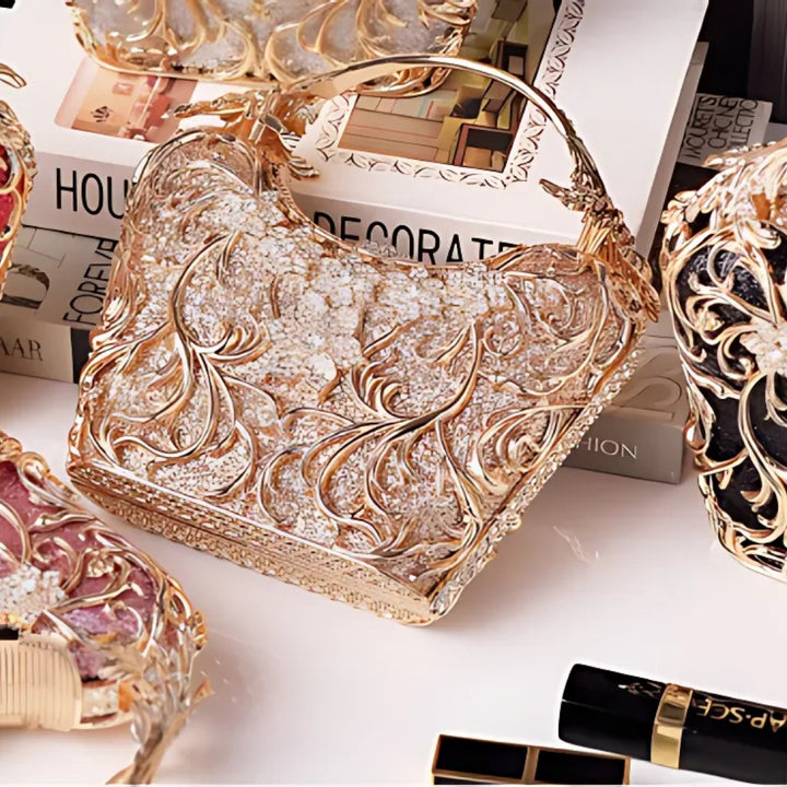 linda Bolsa Feminina clutch festa dourada com acabamento metálico rendado, alça rígida escultural e aplicação de flores em strass, design exuberante e sofisticado – loja Bolsa Clutch