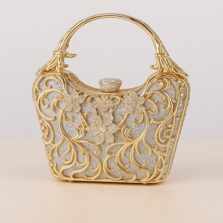 Bolsa feminina clutch festa prata com acabamento metálico dourado rendado, alça rígida escultural e aplicação de flores em strass, design exuberante e sofisticado – loja Bolsa Clutch
