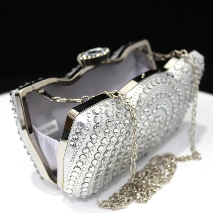Detalhes e visão interna da Bolsa clutch prata com pedrarias em relevo, fecho joia e alça metálica, perfeita para festas de casamento, formaturas e eventos sofisticados - loja Bolsa Clutch
