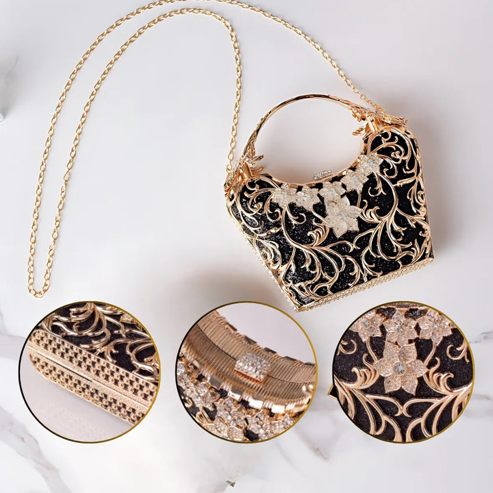 Detalhes externos e luxuosos da Bolsa clutch festa preta com acabamento metálico dourado rendado, alça rígida escultural e aplicação de flores em strass, design exuberante e sofisticado – loja Bolsa Clutch
