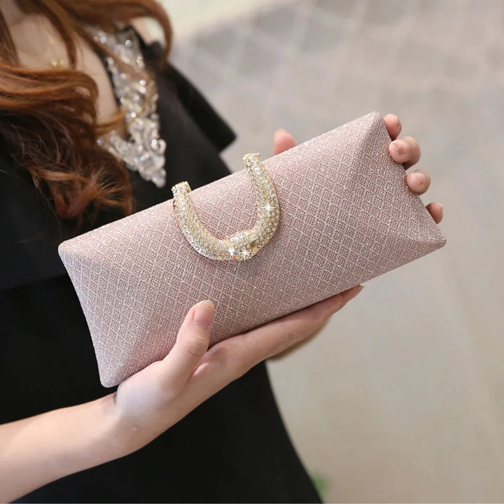 mulher segurando Bolsa clutch de festa rosa com brilho e alça dourada em corrente fina - loja Bolsa Clutch