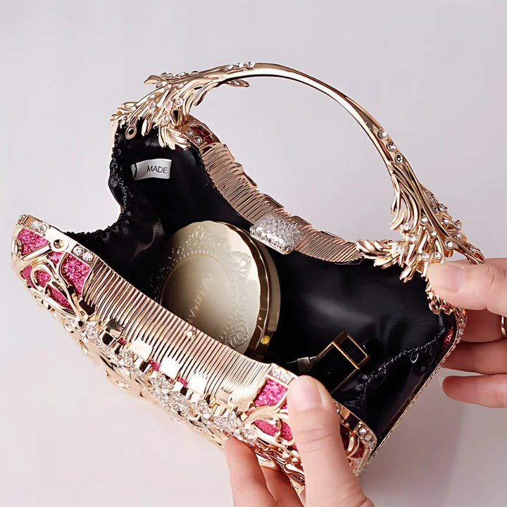 Interior de compartimento único e forrado com tecido premium da Bolsa clutch festa vermelha com acabamento metálico rendado, alça rígida escultural e aplicação de flores em strass, design exuberante e sofisticado – loja Bolsa Clutch