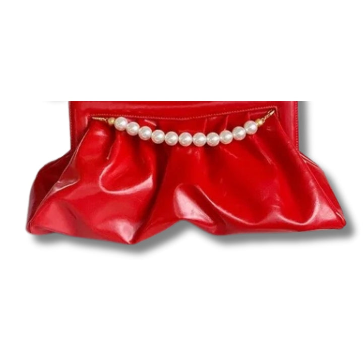 Bolsa clutch festa vermelha vibrante, em material sintético com efeito drapeado e alça superior fixa de pérolas brancas com terminais dourados. Possui fechamento seguro. Ideal para adicionar um toque de cor e glamour a eventos especiais.