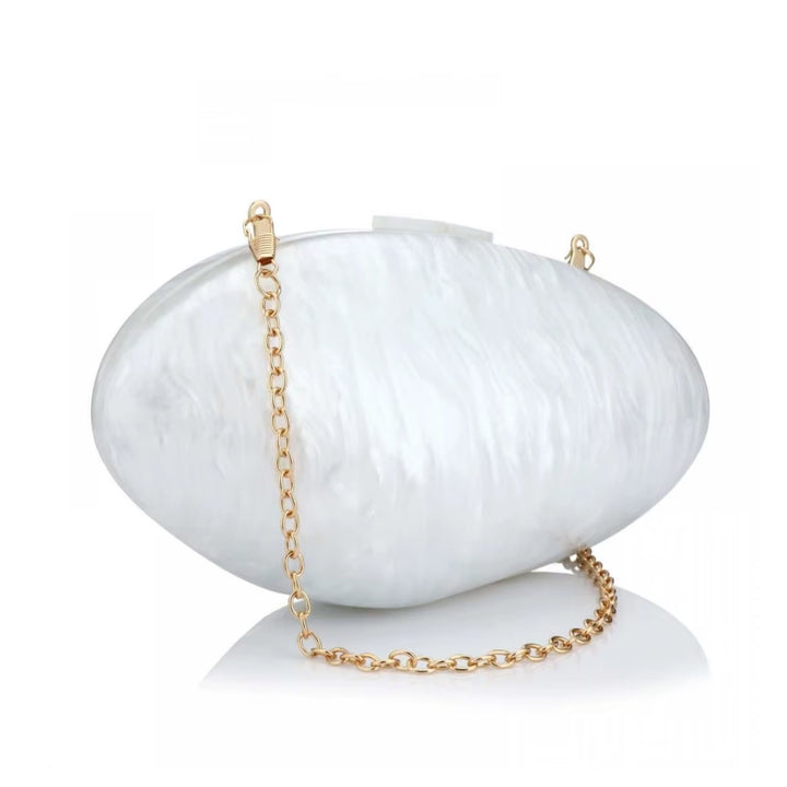 Bolsa clutch branca oval com efeito marmorizado polido e corrente dourada fina, perfeita para eventos luxuosos e casamentos – loja Bolsa Clutch.