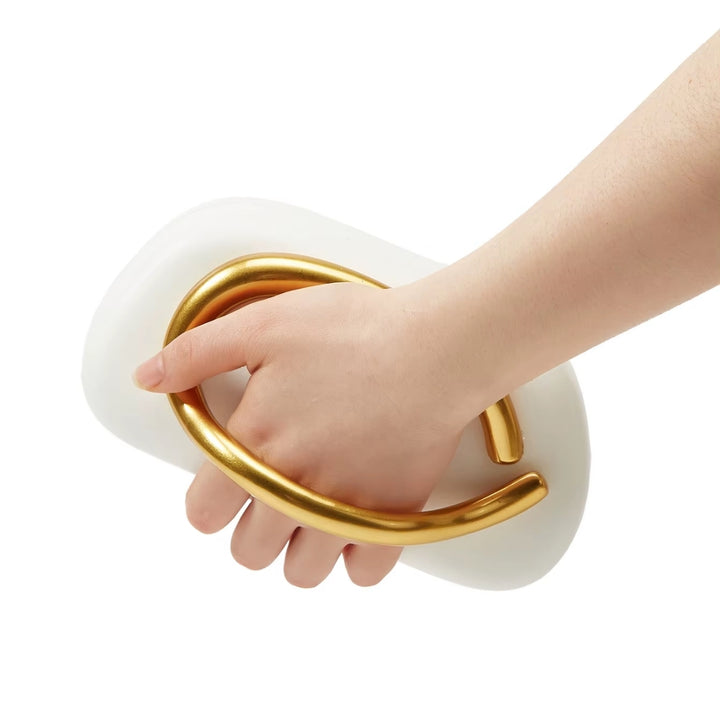 Bolsa clutch festa branca dourada, rígida, com design moderno e alça de mão em metal dourado integrada. Detalhe da alça e zíper dourado interno. Ideal para eventos noturnos.