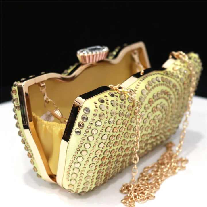 Clutch dourada de festa com pedrarias em espiral e forro interno metálico em dourado, ideal para eventos sofisticados - loja Bolsa Clutch