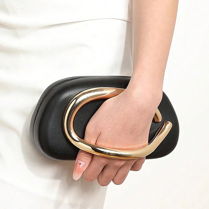 Mão segurando Bolsa clutch festa preta dourada. Design moderno com alça de mão dourada curva integrada e alça de corrente. Ideal para eventos.