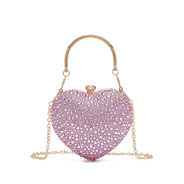 Bolsa festa clutch Feminina rosa em formato de coração, cravejada com cristais azuis vibrantes, alça metálica dourada estruturada e fecho superior com detalhe em pedra – loja Bolsa Clutch