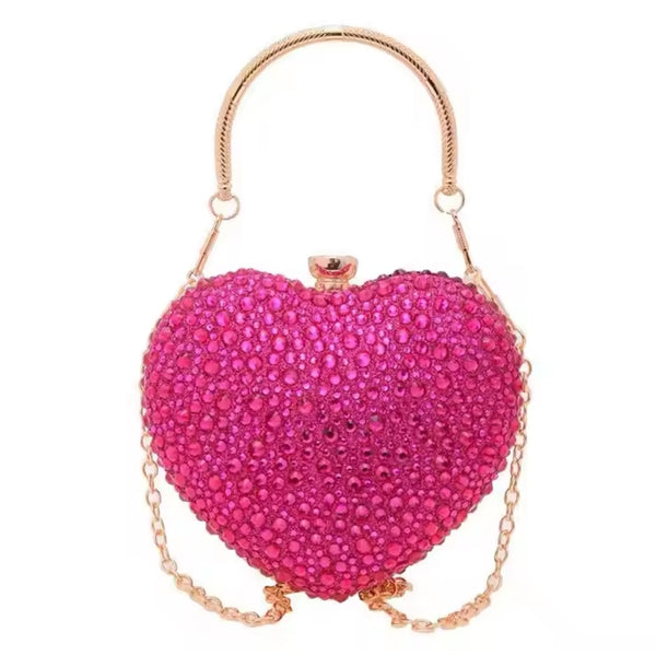 Bolsa  de festa clutch Feminina rosa em formato de coração, cravejada com cristais azuis vibrantes, alça metálica dourada estruturada e fecho superior com detalhe em pedra – loja Bolsa Clutch